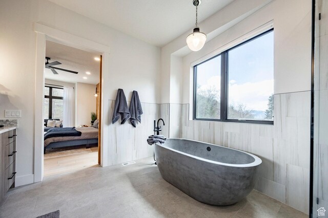 9335 N Canopy Ln E, Sundance, UT 84604 - full bath featuring connected bathroom, a soaking tub, wainscoting, tile walls, and ceiling fan