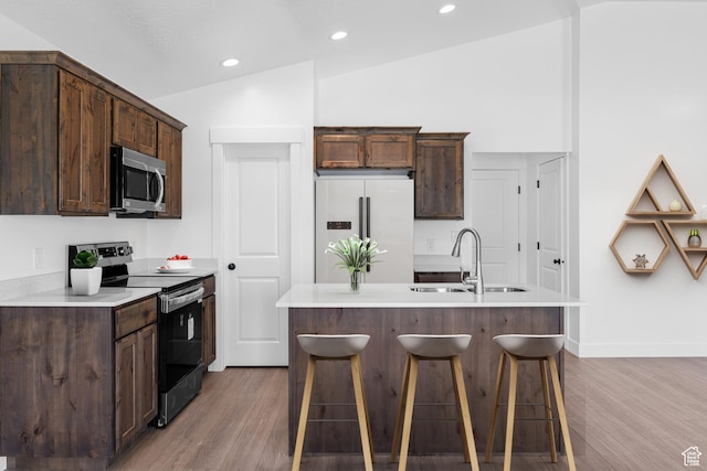 309 N 2350 E Unit 01, Spanish Fork, UT 84660 - kitchen with stainless steel appliances, light wood finished floors, dark brown cabinets, vaulted ceiling, and recessed lighting