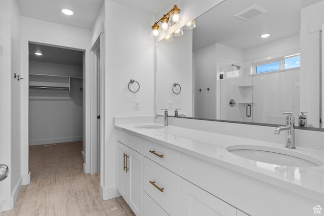 101 N 950 E Unit 36, Tremonton, UT 84337 - bathroom with a shower stall, a walk in closet, double vanity, recessed lighting, and baseboards