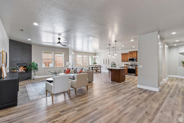 1095 S White Sands Dr, Washington, UT 84780 - living area with a fireplace, light wood-style flooring, recessed lighting, baseboards, and a ceiling fan