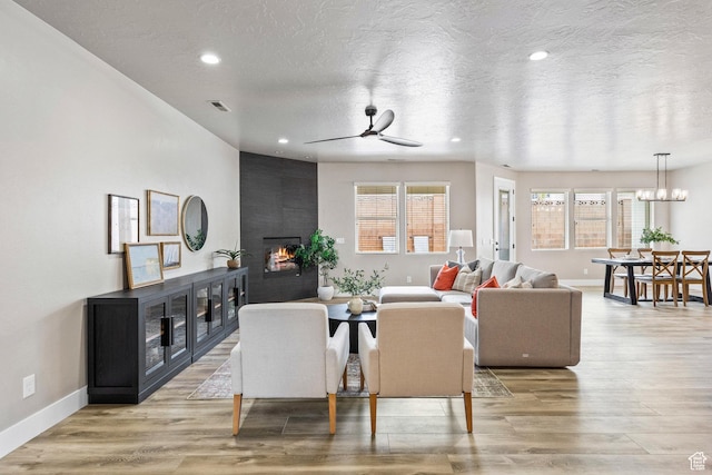 1095 S White Sands Dr, Washington, UT 84780 - living room with a ceiling fan, a fireplace, healthy amount of natural light, baseboards, and a textured ceiling