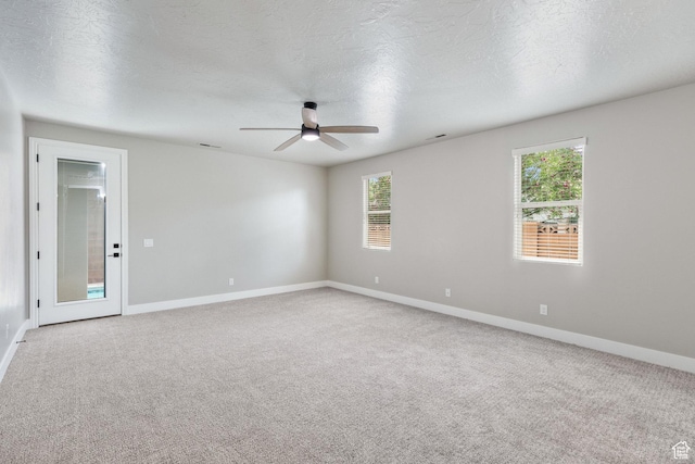 1095 S White Sands Dr, Washington, UT 84780 - empty room featuring a ceiling fan, baseboards, carpet flooring, healthy amount of natural light, and a textured ceiling