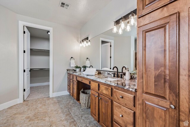 1095 S White Sands Dr, Washington, UT 84780 - full bathroom featuring double vanity, a spacious closet, and baseboards