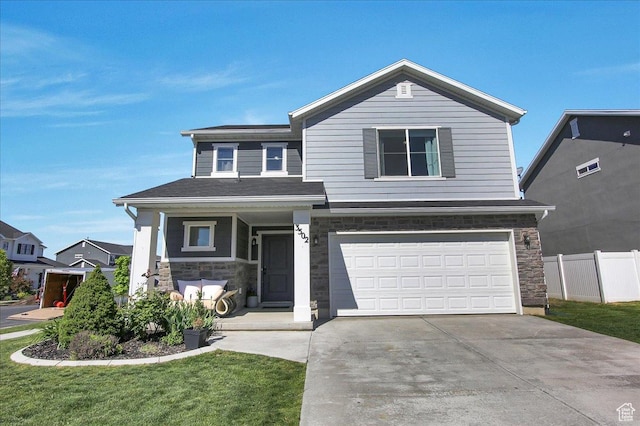 view of front of property with stone siding, covered porch, driveway, and an attached garage