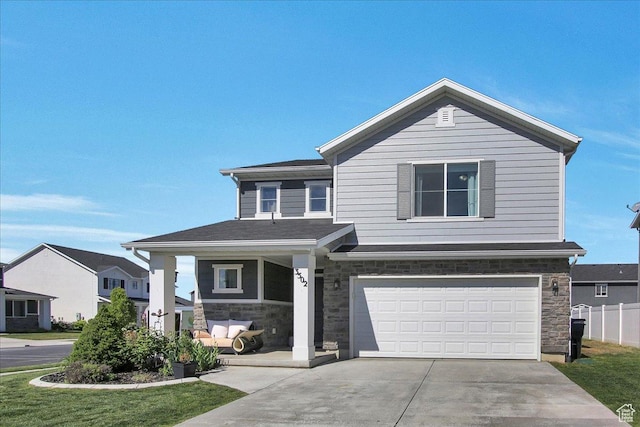 view of front of house with stone siding, concrete driveway, a garage, and fence