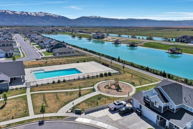 aerial perspective of suburban area with a water and mountain view and a pool