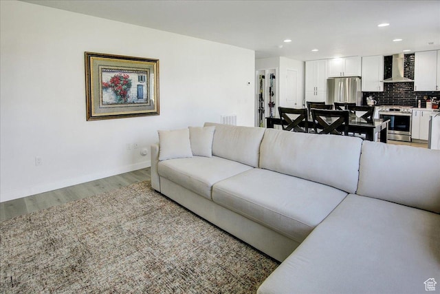 living room with light wood-style floors, baseboards, and recessed lighting