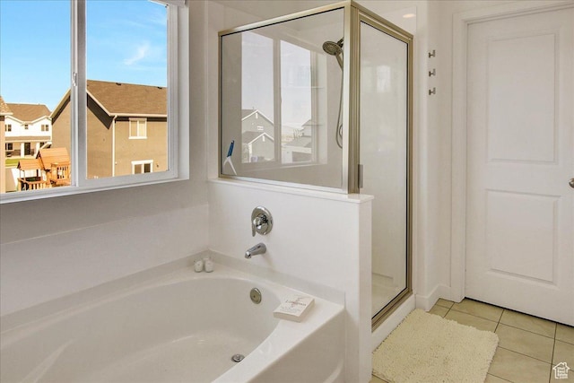 bathroom featuring a shower stall, tile patterned floors, and a garden tub