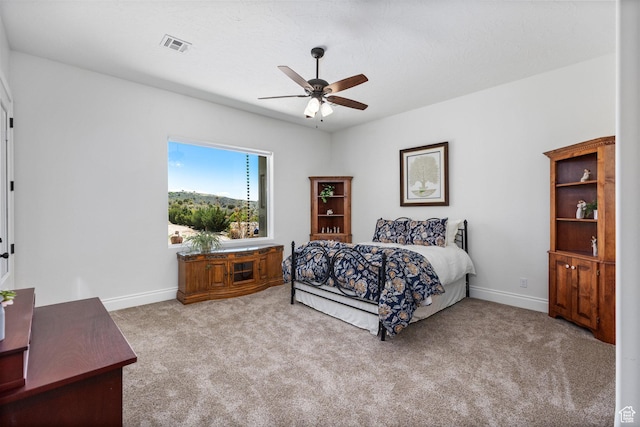 carpeted bedroom featuring baseboards and ceiling fan