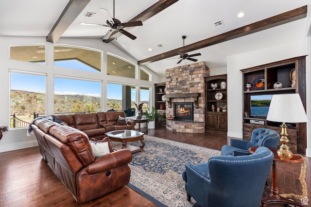 living area featuring ceiling fan, plenty of natural light, wood finished floors, and a stone fireplace