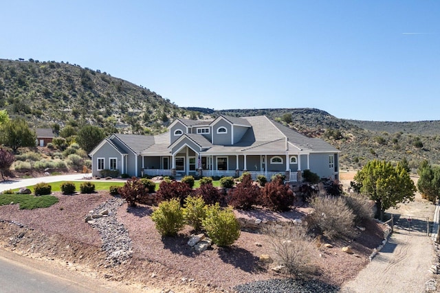 view of front of home with a mountain view, a porch, and a tile roof