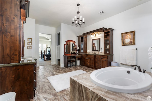 bathroom featuring a chandelier, a garden tub, vanity, and baseboards