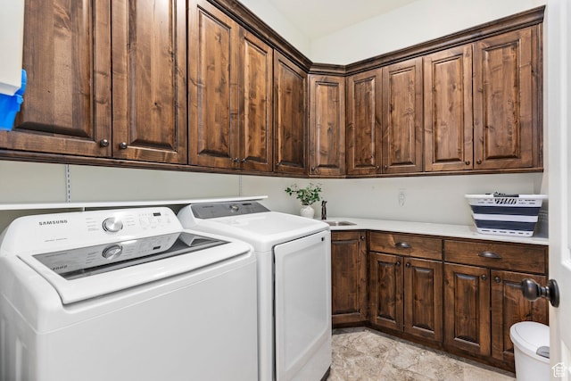 clothes washing area with washing machine and dryer and cabinet space