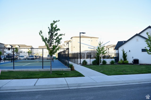 view of tennis court with a residential view