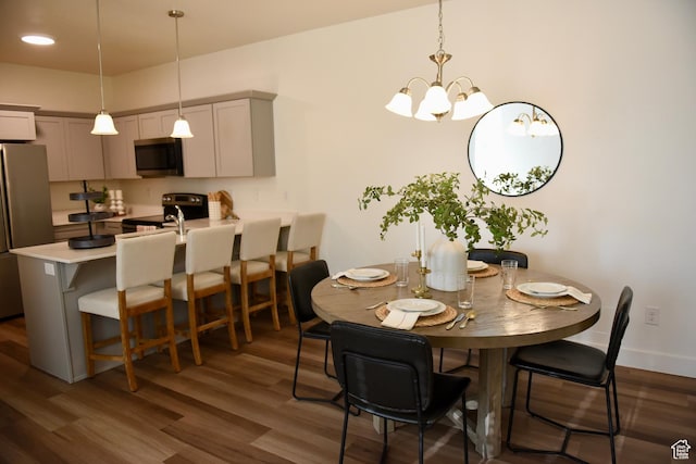 dining room with dark wood finished floors and a chandelier