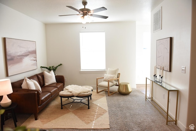 living room featuring a ceiling fan, carpet floors, and baseboards