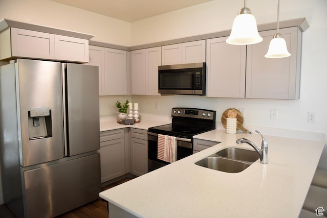 kitchen with stainless steel appliances, a sink, a peninsula, and light countertops