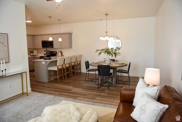 dining space with baseboards, wood finished floors, and a chandelier