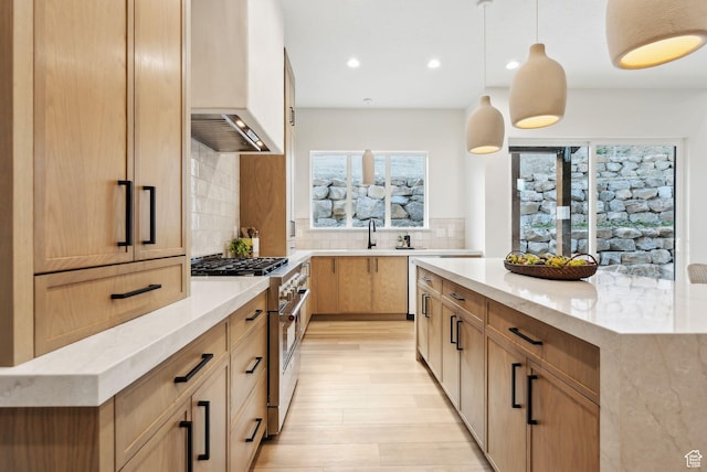 kitchen featuring high end stainless steel range oven, plenty of natural light, custom range hood, light stone counters, and recessed lighting