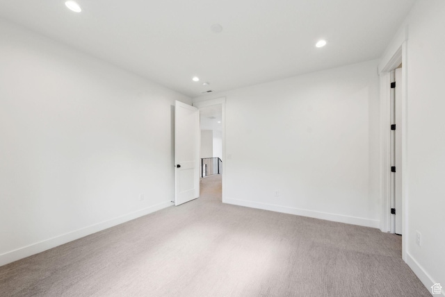 unfurnished room featuring recessed lighting, baseboards, and light colored carpet
