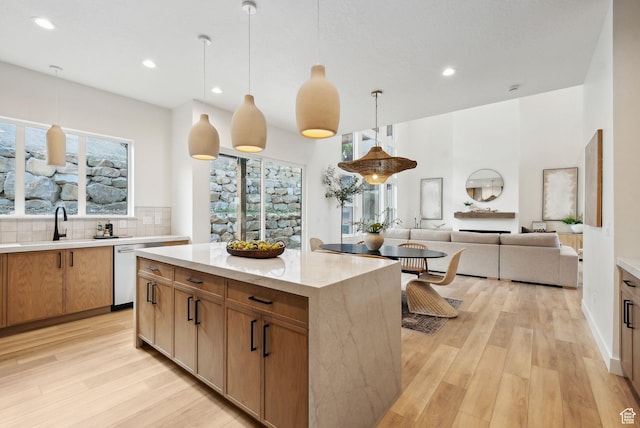 kitchen featuring dishwasher, light wood-type flooring, a sink, pendant lighting, and recessed lighting