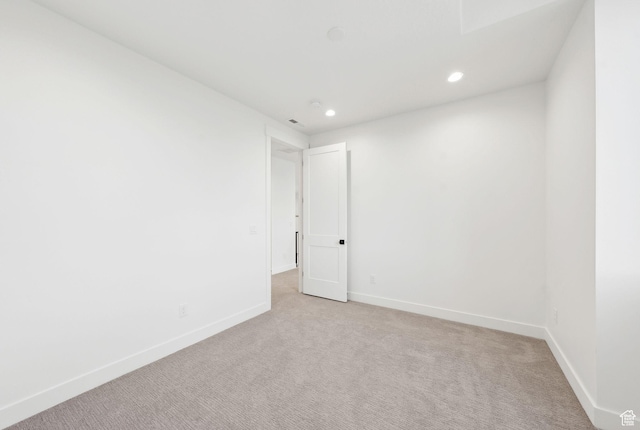 unfurnished room with light carpet, recessed lighting, and baseboards