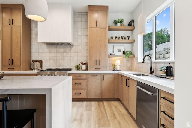 kitchen with dishwasher, a sink, premium range hood, backsplash, and light wood finished floors
