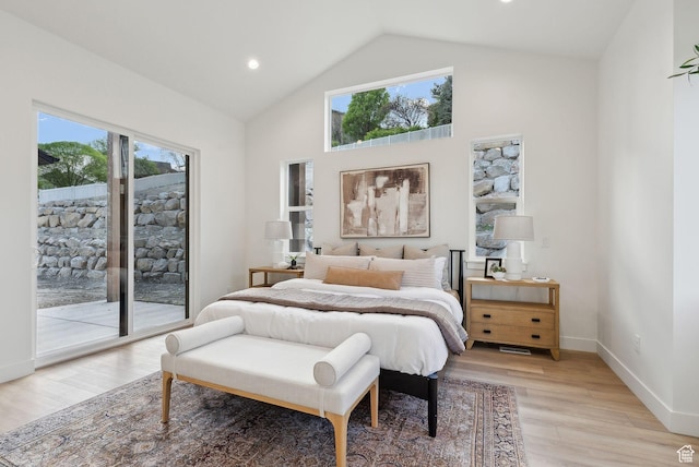 bedroom featuring access to outside, multiple windows, light wood finished floors, baseboards, and high vaulted ceiling