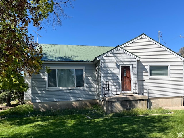 view of front facade featuring a front yard and metal roof
