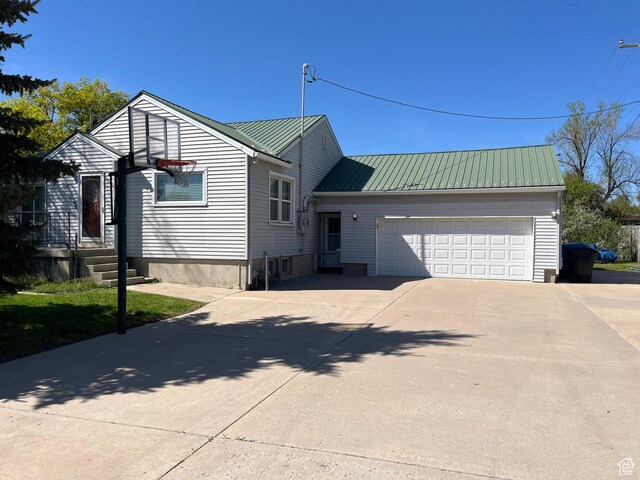 view of front of house with a garage, metal roof, and concrete driveway