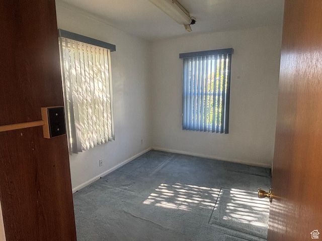 carpeted empty room with baseboards