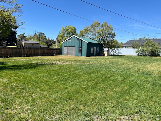 view of yard with a detached garage and an outbuilding