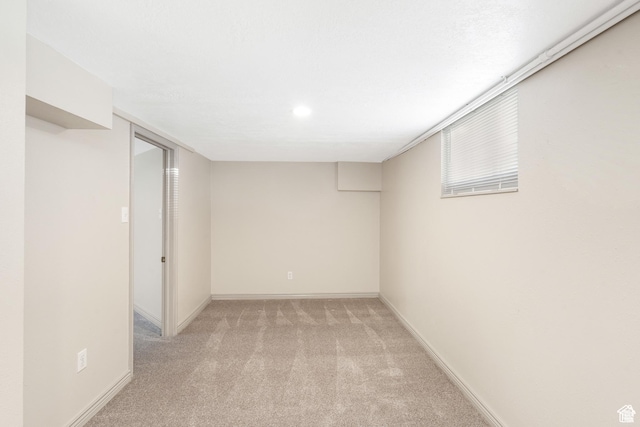 finished basement featuring light carpet and baseboards