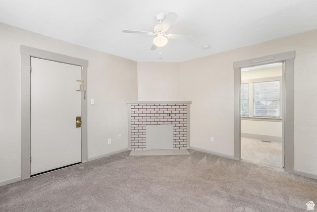 unfurnished living room featuring a ceiling fan, a fireplace with flush hearth, carpet flooring, and baseboards