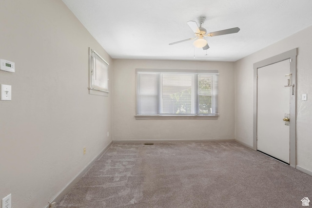 empty room featuring carpet floors, a ceiling fan, and baseboards