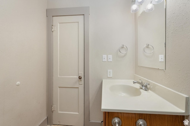bathroom featuring vanity and a textured wall