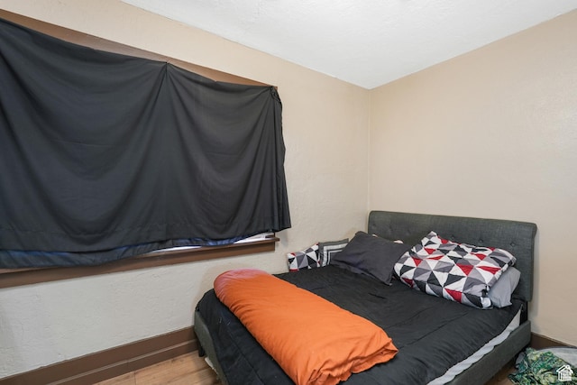 bedroom with baseboards and wood finished floors
