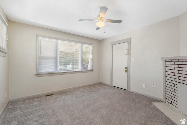 carpeted spare room with a ceiling fan and baseboards