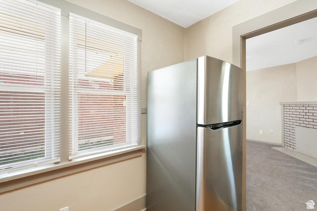 kitchen featuring freestanding refrigerator and carpet
