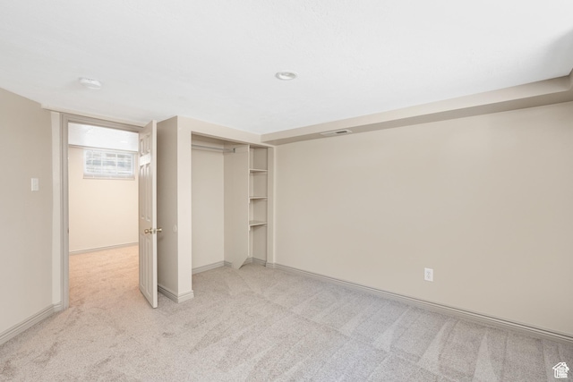 unfurnished bedroom featuring light colored carpet, baseboards, and a closet
