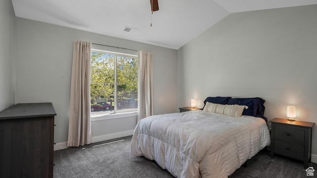 bedroom with dark colored carpet, lofted ceiling, baseboards, and a ceiling fan