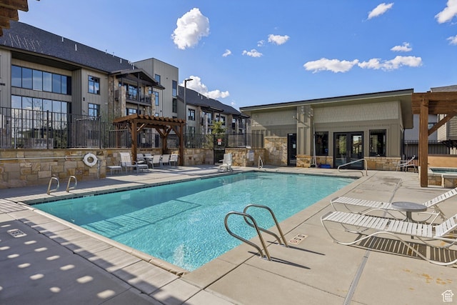 community pool featuring fence, a pergola, a patio, and a hot tub