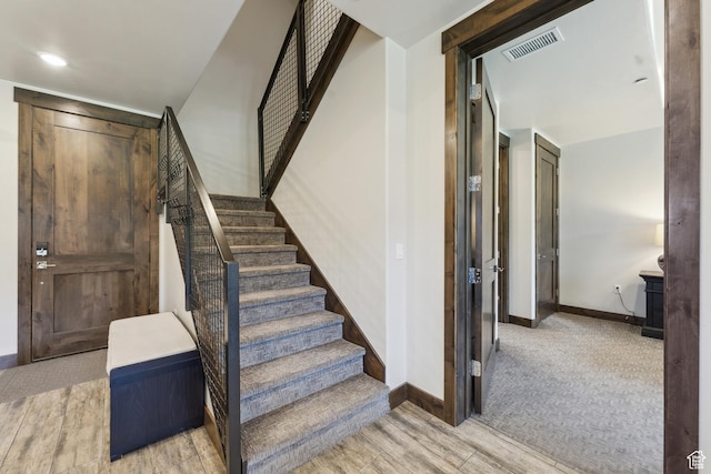 stairway featuring baseboards and wood finished floors