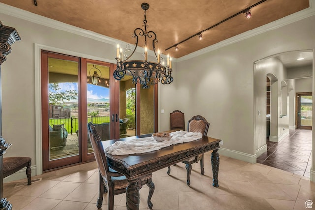 dining space featuring arched walkways, rail lighting, ornamental molding, light tile patterned flooring, and a chandelier