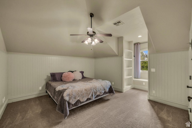 bedroom featuring vaulted ceiling, carpet flooring, wainscoting, a ceiling fan, and baseboards