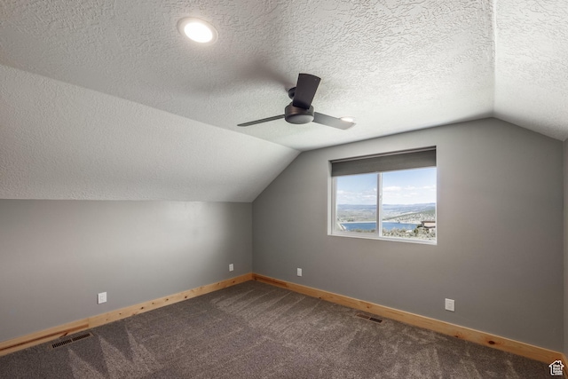 420 E Rockport Aspen Dr, Coalville, UT 84017 - additional living space featuring baseboards, lofted ceiling, a ceiling fan, dark colored carpet, and a textured ceiling