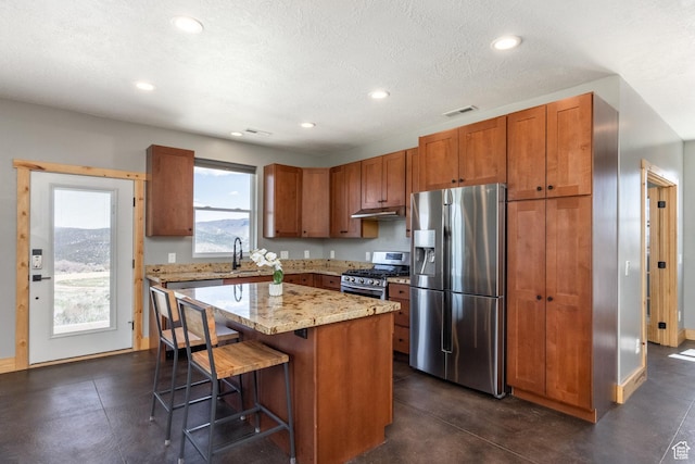 420 E Rockport Aspen Dr, Coalville, UT 84017 - kitchen with appliances with stainless steel finishes, under cabinet range hood, recessed lighting, a breakfast bar area, and a center island