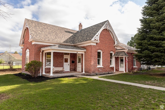 view of front of property with brick siding, roof with shingles, and a chimney