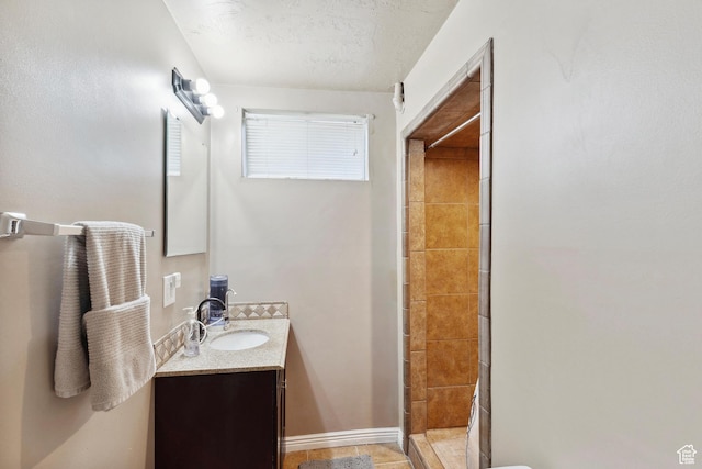 full bath with tiled shower and vanity