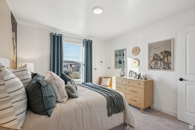 bedroom with light colored carpet and baseboards